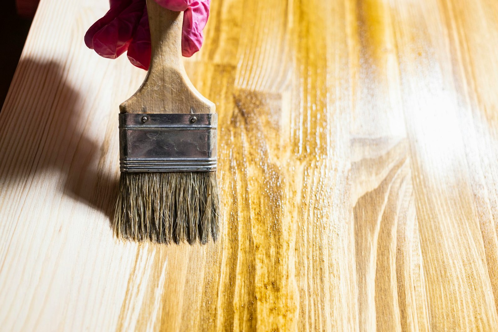 wooden board is covered with wood stain close up